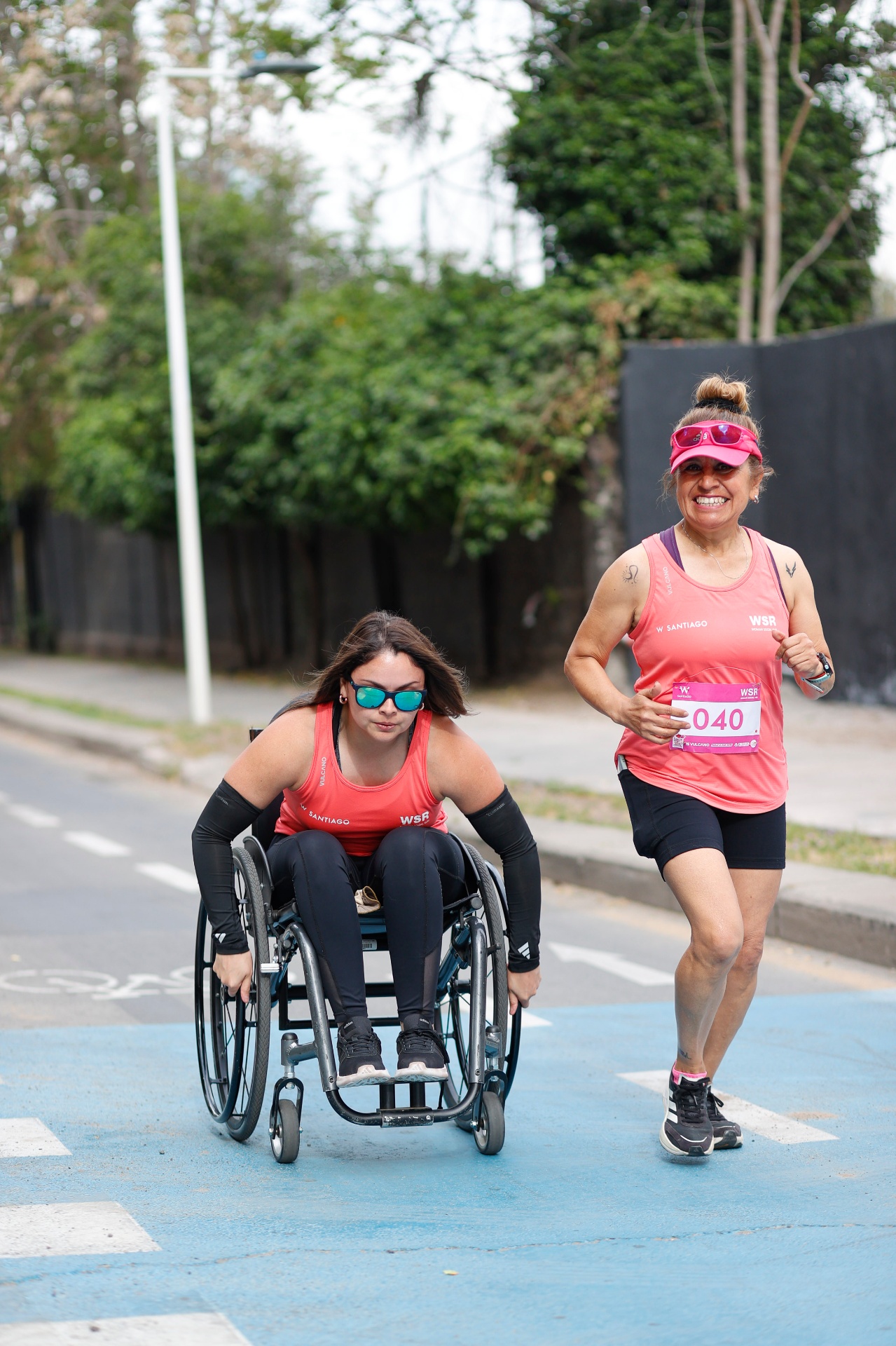 Participante en silla de ruedas acompañada por corredora WSR